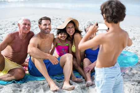 54391748 - cute multi generation family taking a picture on the beach