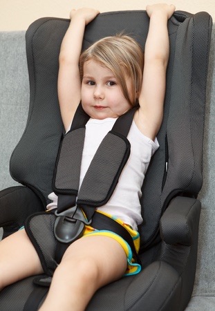 Here's what you want - child sitting in a car safety seat with seatbelt with her own seat.