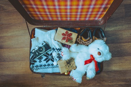 67353745 - open suitcase with casual clothes and gifts for christmas