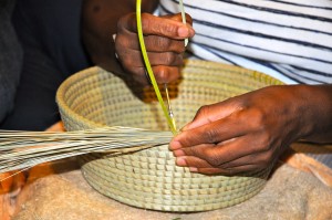 Skilled hands making a sweetgrass basket